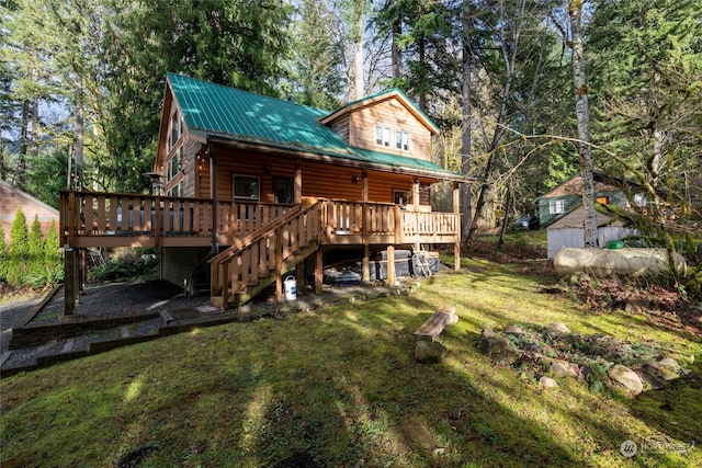 rear view of property with a wooden deck and a yard