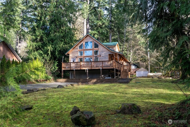 rear view of house with a deck and a lawn