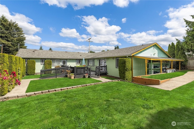 rear view of property featuring a wooden deck and a yard