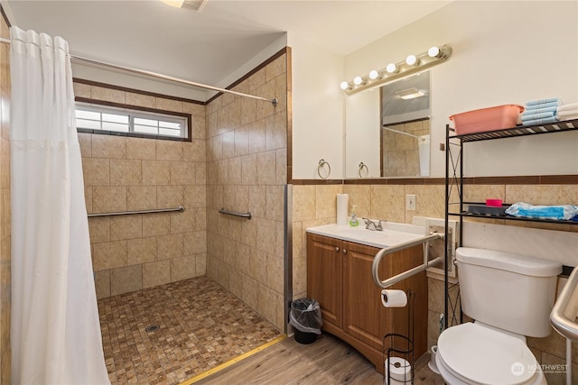 bathroom with curtained shower, hardwood / wood-style floors, vanity, tile walls, and toilet