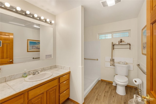 bathroom featuring a shower, wood-type flooring, toilet, and vanity