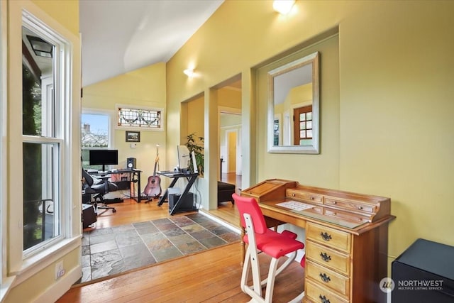 office space featuring a wealth of natural light, dark hardwood / wood-style floors, and vaulted ceiling