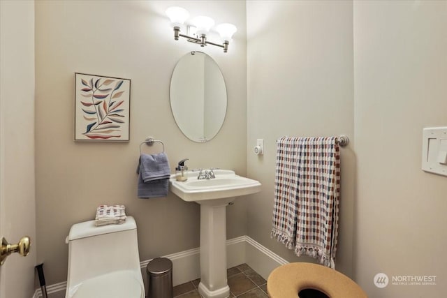 bathroom with toilet, tile patterned flooring, and sink