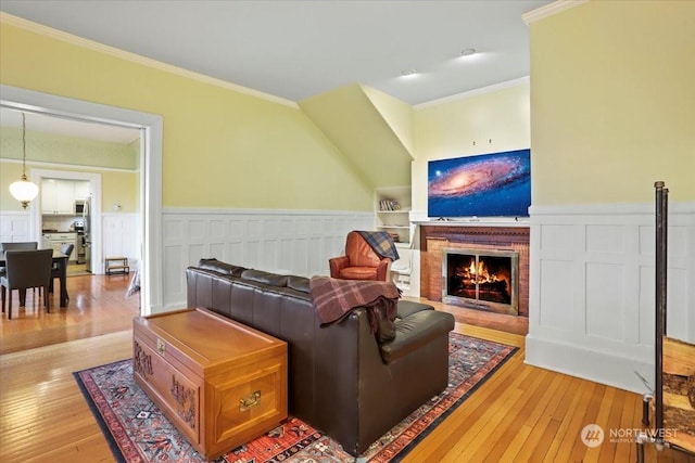 living room with crown molding and light hardwood / wood-style floors