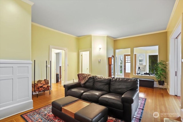 living room with light wood-type flooring and ornamental molding