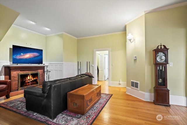 living room with crown molding and light wood-type flooring