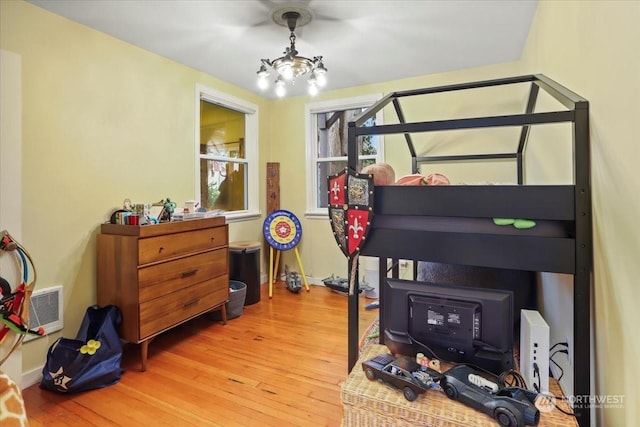 bedroom with a chandelier and hardwood / wood-style floors