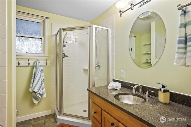 full bathroom with vanity, baseboards, a stall shower, and tile patterned flooring