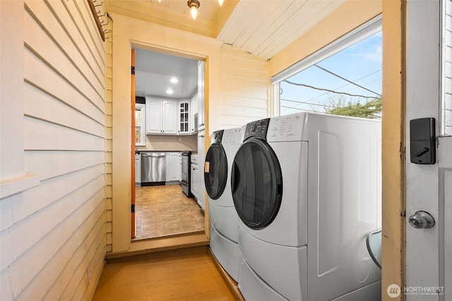 laundry room with light wood-type flooring, laundry area, and washing machine and clothes dryer