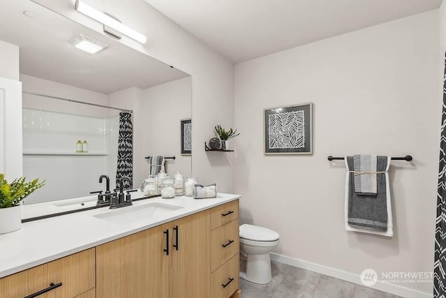 bathroom featuring toilet, vanity, and tile patterned flooring