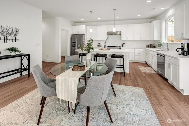 dining space featuring light hardwood / wood-style floors and sink