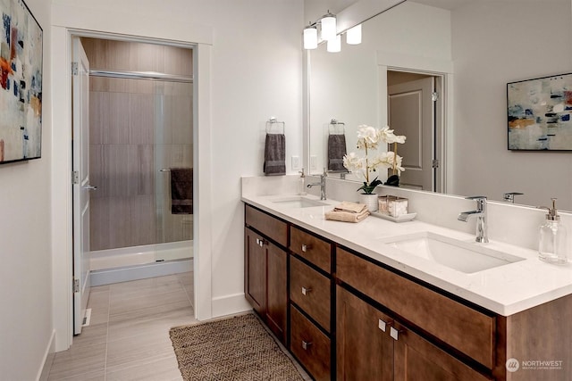 bathroom featuring tile patterned flooring, an enclosed shower, and vanity