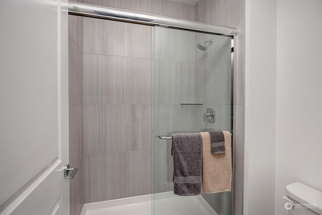 bathroom featuring an enclosed shower and toilet