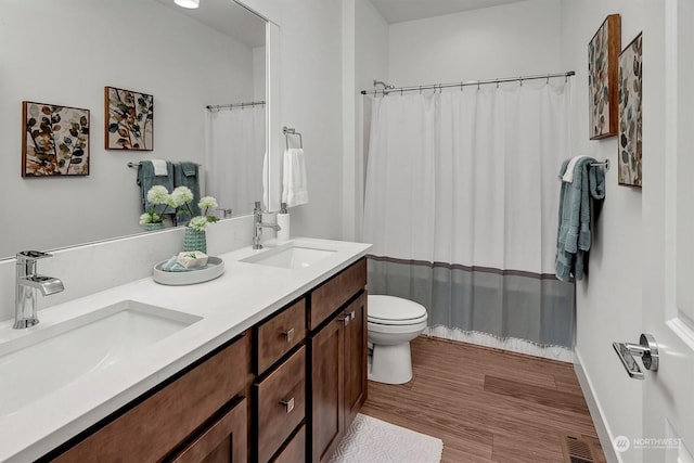 bathroom with toilet, a shower with shower curtain, wood-type flooring, and vanity