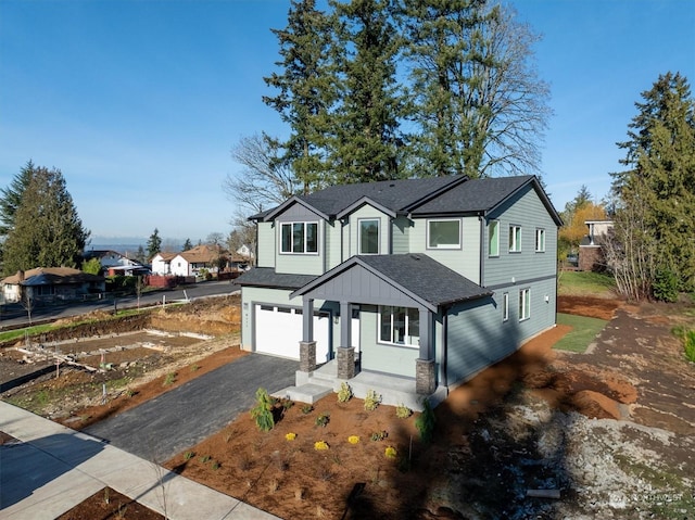 view of front of home featuring aphalt driveway, a shingled roof, and a garage