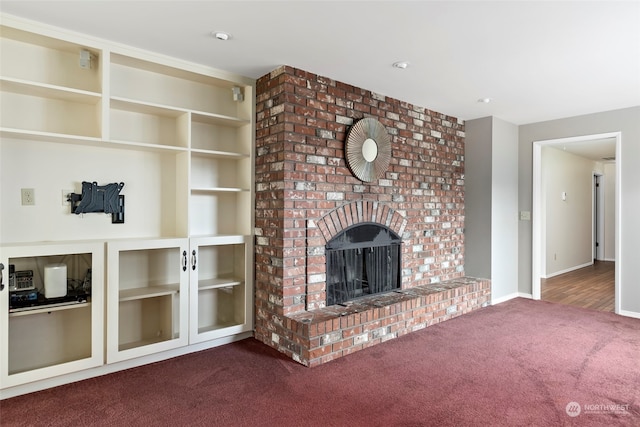 unfurnished living room with a fireplace and dark colored carpet