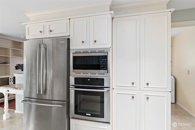 kitchen featuring crown molding, appliances with stainless steel finishes, and white cabinets