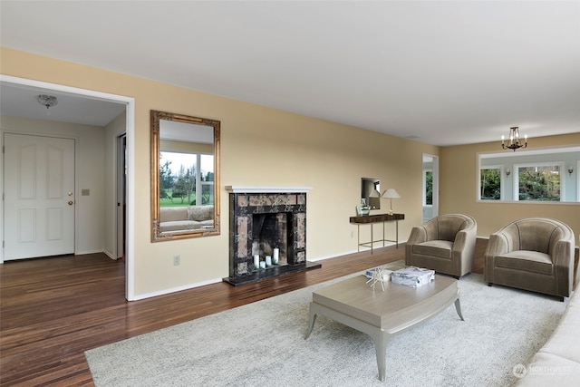 living room with dark wood-type flooring, a premium fireplace, and a wealth of natural light