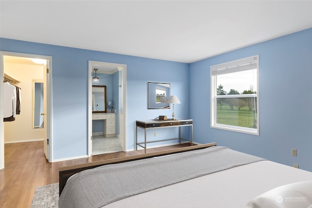 bedroom featuring hardwood / wood-style floors and ensuite bath