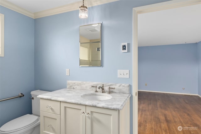 bathroom with vanity, hardwood / wood-style flooring, crown molding, and toilet