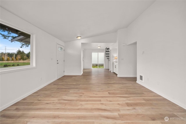 unfurnished room featuring light wood-type flooring and vaulted ceiling