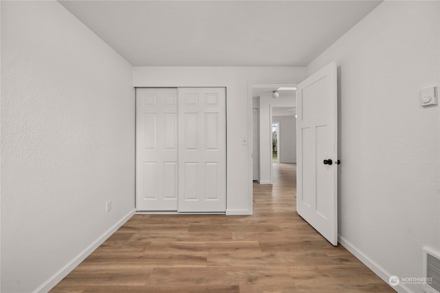 unfurnished bedroom featuring hardwood / wood-style flooring and a closet