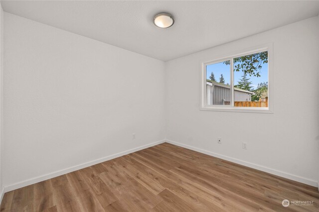 unfurnished room with wood-type flooring