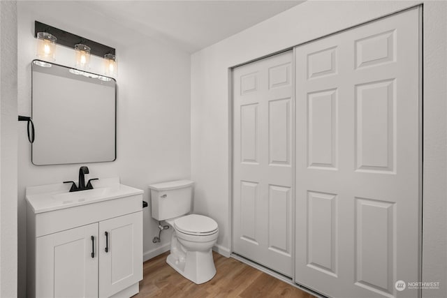 bathroom featuring toilet, vanity, and wood-type flooring