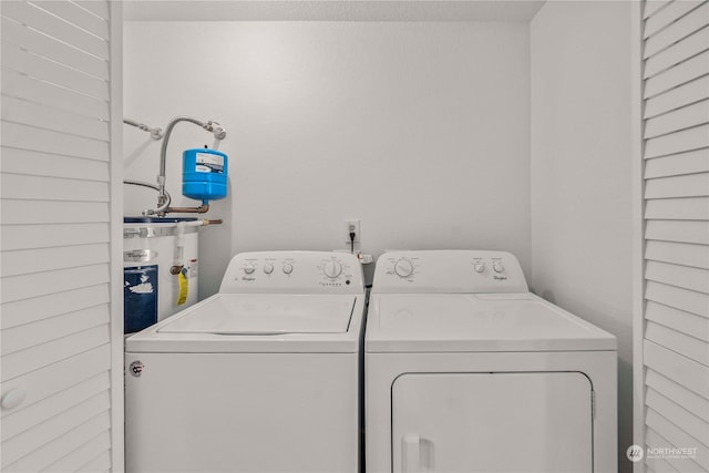 washroom with water heater and independent washer and dryer