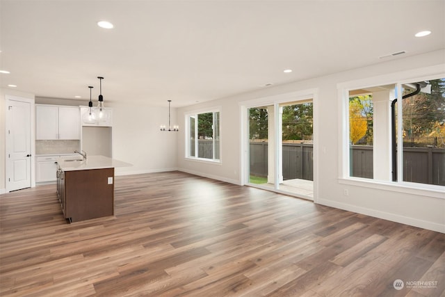 unfurnished living room featuring sink, dark hardwood / wood-style floors, and a notable chandelier