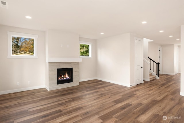 unfurnished living room featuring a fireplace and dark wood-type flooring