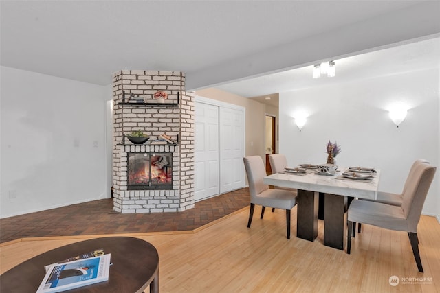 dining area featuring a fireplace and beamed ceiling