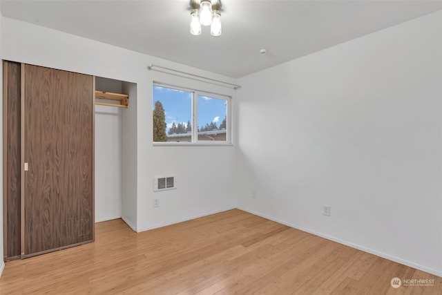 unfurnished bedroom featuring a closet and light hardwood / wood-style flooring