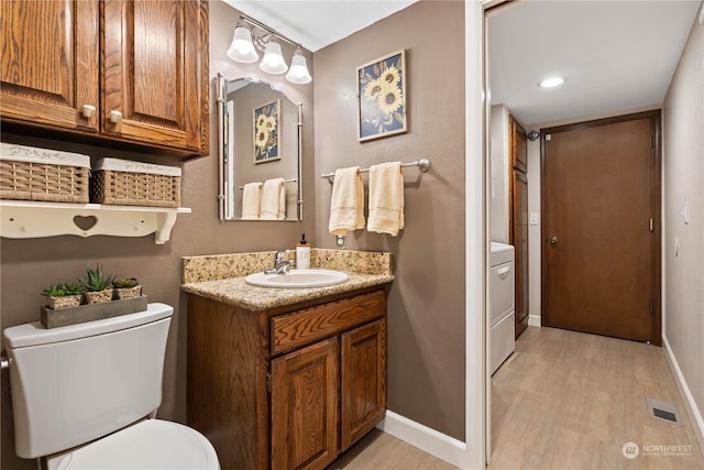 bathroom featuring wood-type flooring, vanity, and toilet