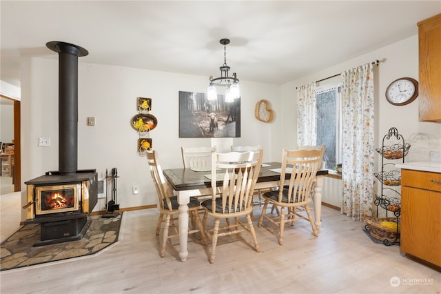 dining space featuring a wood stove and light hardwood / wood-style floors