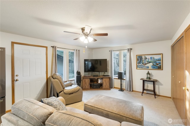 living room featuring ceiling fan, light colored carpet, french doors, and a healthy amount of sunlight