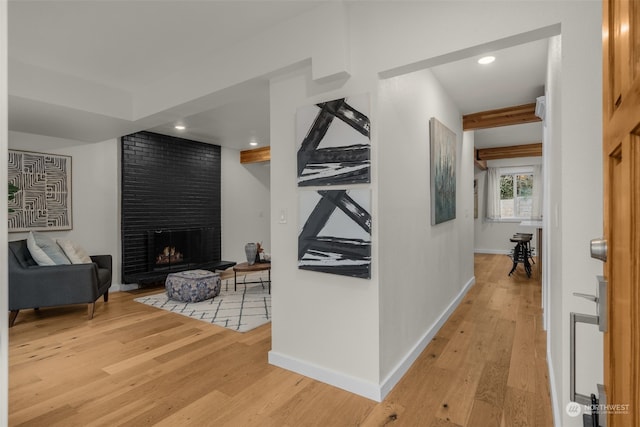 hall with beam ceiling and light wood-type flooring