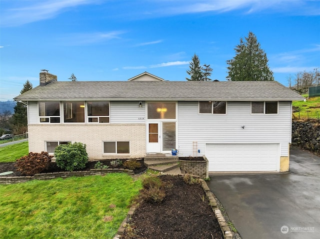 split foyer home featuring a front lawn and a garage