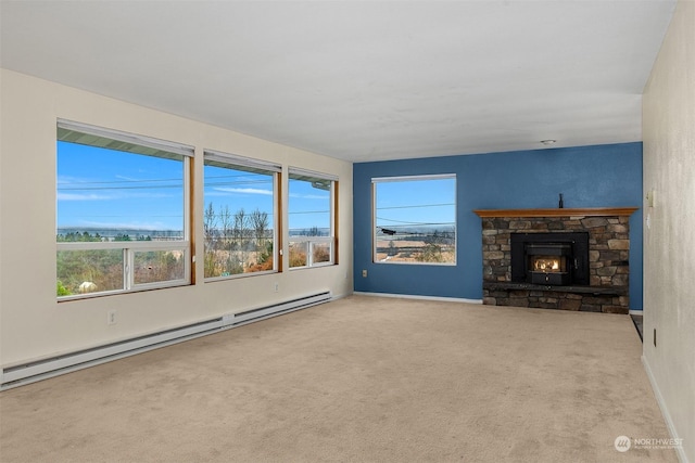 unfurnished living room with a baseboard heating unit, carpet floors, and a stone fireplace