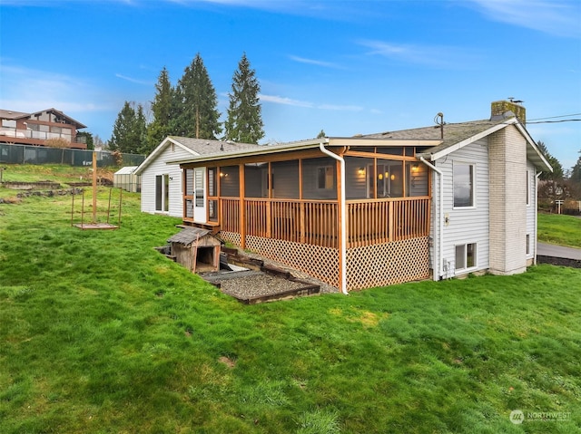 back of property featuring a lawn and a sunroom