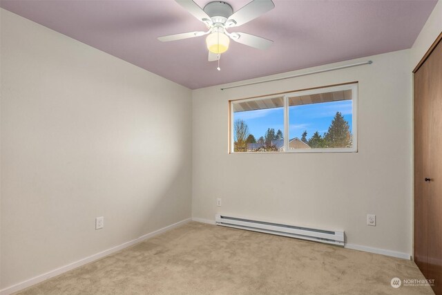 spare room with a baseboard heating unit, ceiling fan, and light carpet