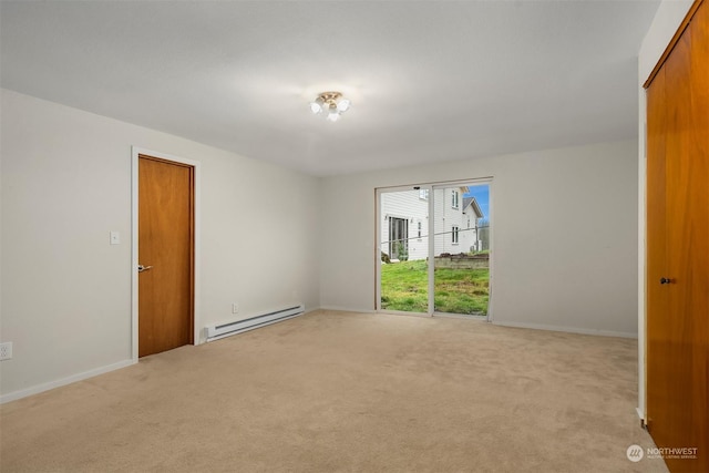 spare room with a baseboard radiator and light colored carpet