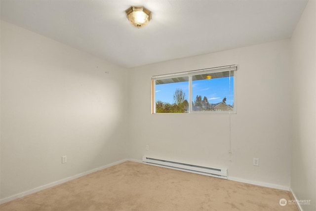 spare room with light carpet and a baseboard heating unit