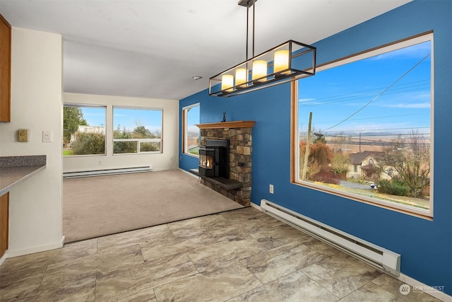 unfurnished living room with baseboard heating and a stone fireplace