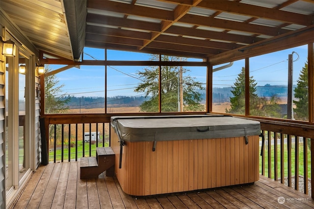 unfurnished sunroom with vaulted ceiling and a jacuzzi