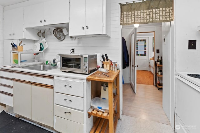 kitchen featuring sink, white cabinets, and white electric range