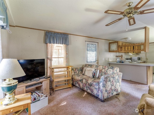 carpeted living room with ornamental molding and ceiling fan