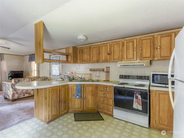 kitchen featuring sink, white appliances, a textured ceiling, and kitchen peninsula