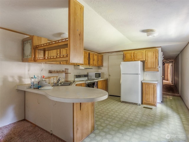 kitchen with white appliances, sink, lofted ceiling, and kitchen peninsula