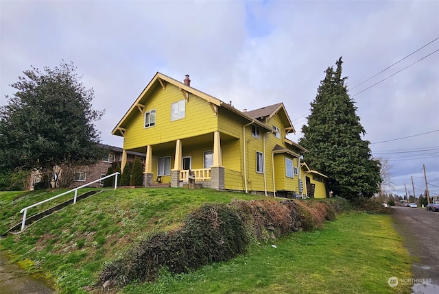 view of front facade featuring a front yard and covered porch